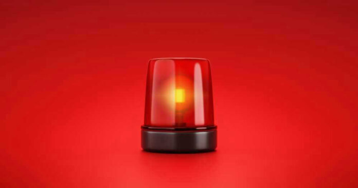 shutterstock_2053758056-1.jpg Red emergency light on solid red background