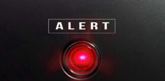 Red alert light against black background, text ALERT