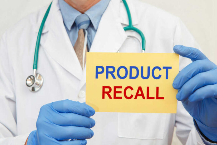 shutterstock_1849024102.jpg Doctor holding a product recall sign in gloves
