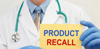 Doctor holding a product recall sign in gloves