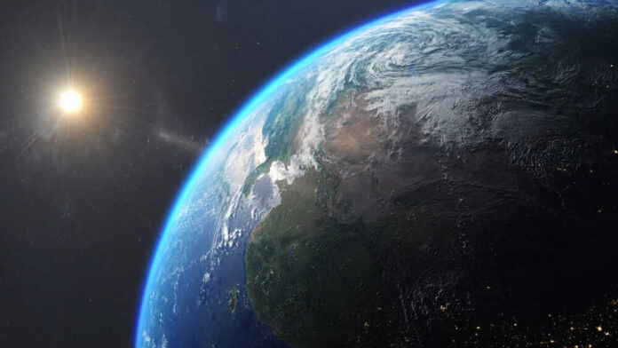 Earth from space with sun in background.