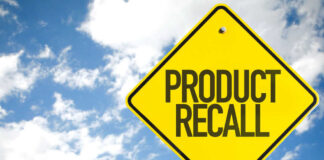 Yellow product recall sign against cloudy sky