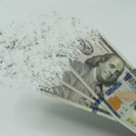 Hundred-dollar bills disintegrating in hand.