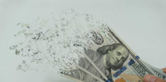 Hundred-dollar bills disintegrating in hand.