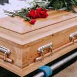GUNNED DOWN: Top American Scientist Dead Wooden casket with red roses on top