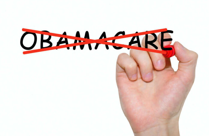Hand crossing out the word Obamacare in red