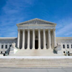 U.S. Supreme Court building under clear blue sky.