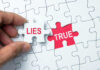 A hand holding a puzzle piece labeled 'LIES' next to a piece labeled 'TRUE'