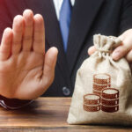 Trump HALTS Collections — Watchdogs FURIOUS Businessman holding a money bag with a raised hand signaling refusal