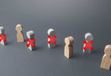 Wooden figures representing people with red crosses indicating exclusion