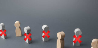 Wooden figures representing people with red crosses indicating exclusion
