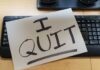 A resignation letter reading 'I QUIT' placed on a keyboard