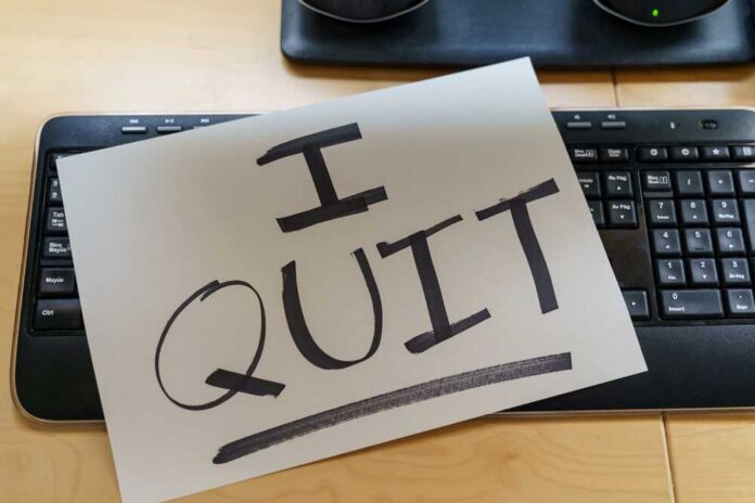 A resignation letter reading 'I QUIT' placed on a keyboard