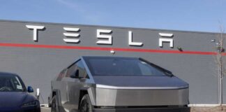 Tesla Cybertruck parked in front of a Tesla dealership