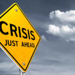 A yellow warning sign indicating a crisis ahead