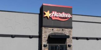 Exterior view of a Hardee's restaurant with a black car parked in front