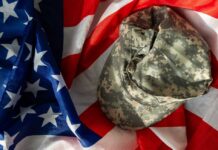 Camouflage military cap resting on an American flag