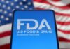 FDA U-Turn Stuns Concerned Americans FDA logo displayed on a smartphone with an American flag background