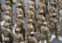 A formation of soldiers in military uniforms marching in a parade