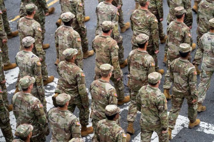 shutterstock_2641594407.jpg A formation of soldiers in military uniforms marching in a parade