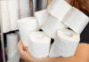 Person holding multiple rolls of toilet paper