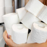 Person holding multiple rolls of toilet paper