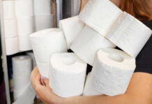 Person holding multiple rolls of toilet paper