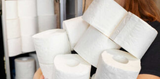 Person holding multiple rolls of toilet paper
