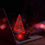Signal INTERCEPTED — Sleeper Cells Activated? Warning symbol over laptop with user.