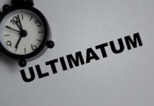 Trump’s Ultimatum Stuns the World A black alarm clock next to the word 'ULTIMATUM' on a gray background