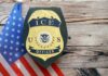 ICE officer badge displayed next to the U.S. flag