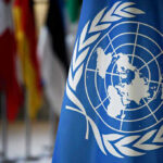 United Nations flag with other flags in background.