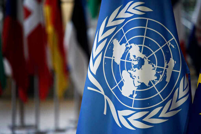 1091235845 United Nations flag with other flags in background.