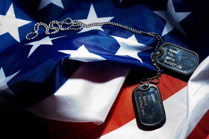 shutterstock_1960819849.jpg Military dog tags resting on an American flag