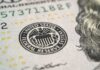 Close-up of a United States dollar bill featuring the Federal Reserve emblem