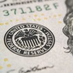 Close-up of a United States dollar bill featuring the Federal Reserve emblem