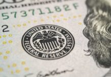 Close-up of a United States dollar bill featuring the Federal Reserve emblem