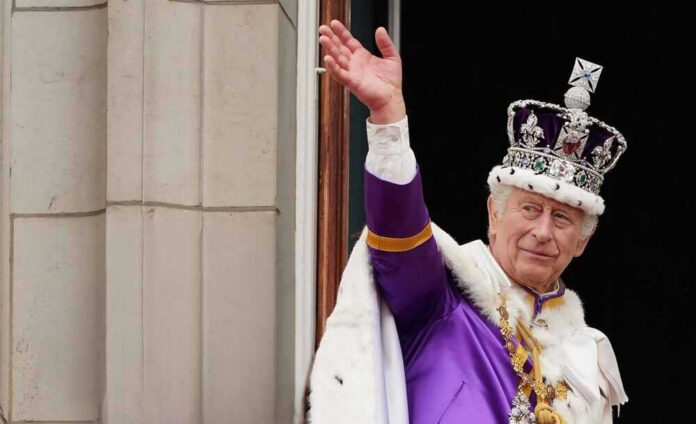 shutterstock_2338087303-1.jpg Man in royal attire and crown waving, stone background.