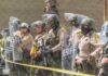 Line of police officers in riot gear standing behind shields