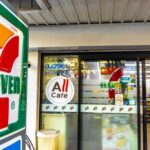 7-Eleven COLLAPSE Accelerates — 645 Stores CLOSING Exterior view of a 7-Eleven convenience store with All Cafe signage