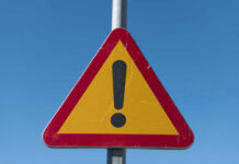 Deadly Crash Shocks U.S. – Many Casualties Triangular warning sign with exclamation mark.