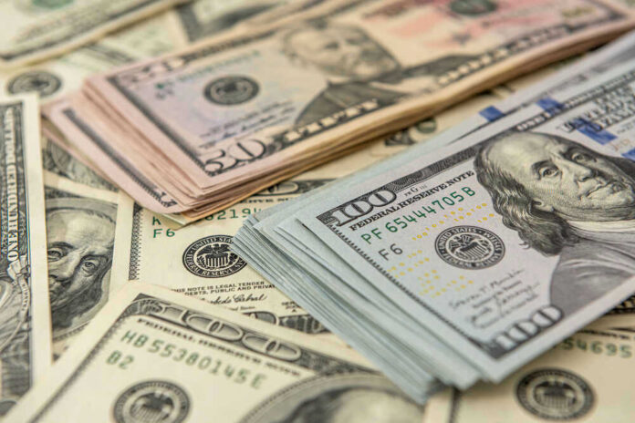 shutterstock_1936085086 Stacks of US dollars featuring Benjamin Franklin and Ulysses S. Grant.