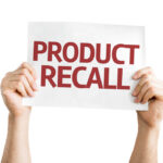 Burn Hazard ALERT: Premium Product Recalled! Hands holding a sign that reads 'PRODUCT RECALL'