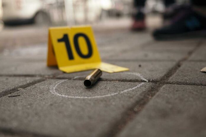 Bullet,Casing,And,Evidence,Marker,Number,10,On,Urban,Pavement Bullet casing on the ground next to a numbered evidence marker