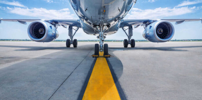 shutterstock_637037008.jpg Airplane on runway with visible landing gear engines