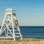 Lifeguard chair on sandy beach near ocean