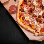 Pizza Icon Dumped — Why Now? A pizza with various toppings in a delivery box