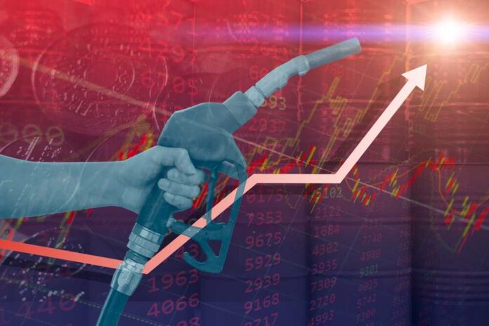Fuel,Gas,Price,Hit,New,High,Record.,Gasoline,Global,Cost Hand holding a fuel nozzle with rising graph lines in the background