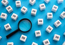Jobs Boom, Tech BLOODBATH Magnifying glass among cubes labeled job on blue background
