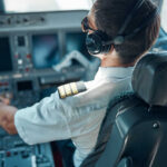 Hero Pilot’s Heartbreaking Turn Revealed Pilot in cockpit wearing headphones and operating aircraft controls